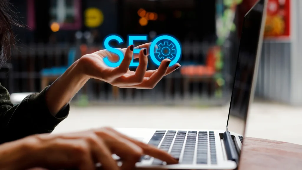 Hand reaching out to an SEO icon with gears representing outsourcing SEO to the Philippines for enhanced efficiency.